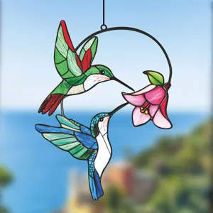 Detailed view of colorful stained glass hummingbird and flower hanging window ornament.