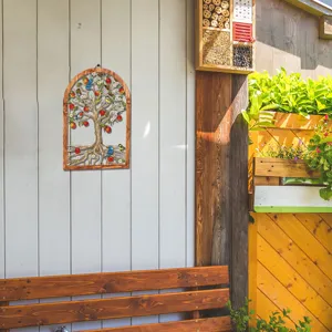 Detail view of the wooden frame metal tree wall art hanging on outdoor garden wall decor.