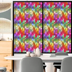 Detail van kleurrijke raamfolie met levendig verloopmotief op glas in een kamer.