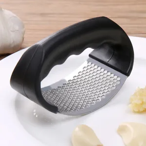 Stainless steel manual garlic press kitchen tool, curved metal mincer with black handle.