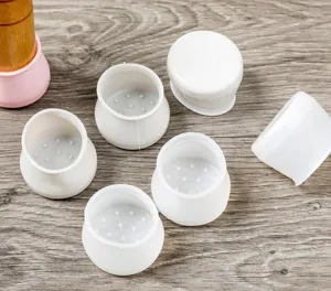 Detail view of white silicone chair leg protectors showing textured bottom anti-slip design.