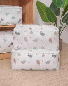 Detail view of foldable fabric quilt storage bag featuring cute forest cartoon print pattern.