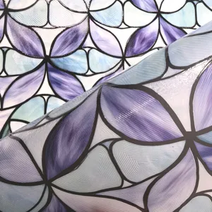 Detailed view of 3D embossed stained glass window film with purple floral pattern texture.