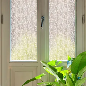 Detailed view of white floral lace static window film applied on clear glass, home decor.