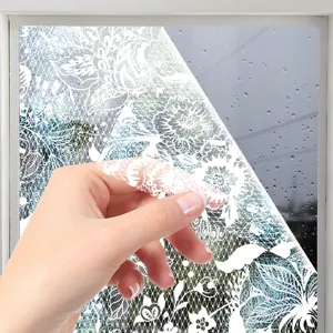 Close-up view of white lace pattern static window film being peeled, glass sticker detail