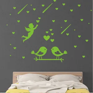 Gros plan d'autocollants muraux lumineux avec ange mignon et oiseaux pour une déco de chambre.