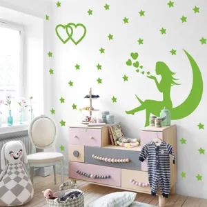 Détail de sticker mural lumineux avec fée et étoiles dans une chambre d'enfant douillette.