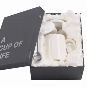 Detailed view of luxury ceramic coffee mug set in black gift box with white satin lining.