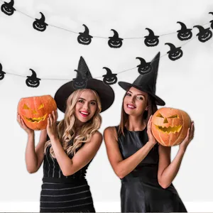 Halloween Party Deko Szene Detail mit schwarzer Kürbis Girlande und festlichen Requisiten.