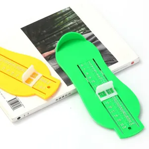 Detailed shot of plastic infant foot measuring devices in green and yellow with clear scale.