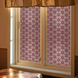 Gedetailleerd overzicht van rode geometrische raamfolie aangebracht op glas, interieur.