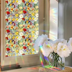 Close-up detail of colorful floral window film casting beautiful rainbow refractions on glass.
