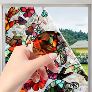 Stained glass window film detail showing decorative turtle and floral sticker design.