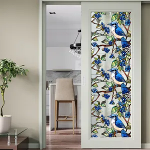 Film pour vitrage en verre teinté avec motif d'oiseau bleu et de baies pour porte vitrée.