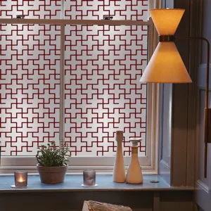Film décoratif géométrique pour fenêtre, motif croix rouge pour intimité et protection solaire.