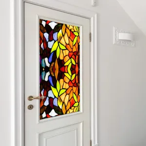 Detailed view of colorful vintage stained glass window film applied on white door for home decor.