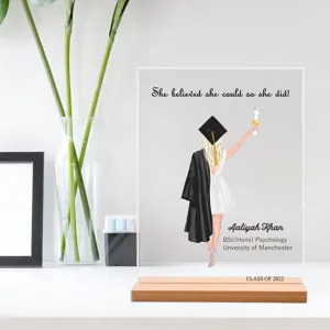 Gepersonaliseerde acryl afstudeerplaat met houten basis als bureaudecoratie voor studenten.