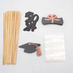 Graduation 2024 cake topper DIY set with wooden sticks and glitter paper graduation cap decor.