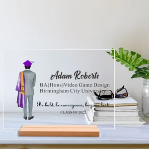 Gedetailleerd overzicht van een gepersonaliseerde acryl afstudeerplaat op marmeren bureau.