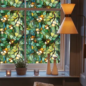 Détail du film pour vitrage vitrail avec motif de feuilles vertes et jaunes dans la pièce.