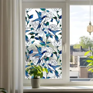 Film décoratif pour vitre en verre teinté avec motif d'oiseaux bleus et roses blanches, statique.