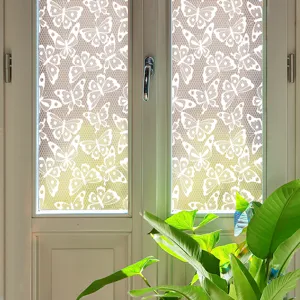 Close-up of white butterfly lace window film on glass, creating elegant privacy and decor effect.