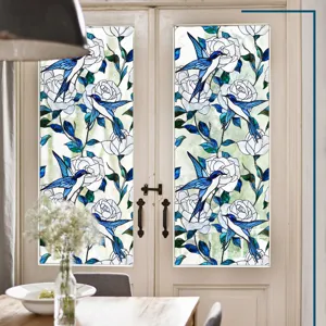 Vue détaillée du film pour fenêtre en vitrail avec motif floral d'oiseau bleu et rose blanche.