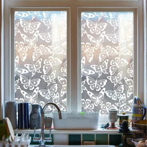 Detail shot of white lace butterfly window film applied on kitchen glass, offering privacy and style.