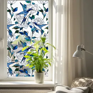 Détail de film pour vitre en verre teinté oiseau bleu dans un décor intérieur lumineux.