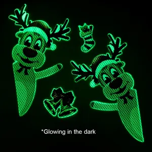 Primo piano ravvicinato di adesivi natalizi luminosi e riflettenti che brillano al buio.
