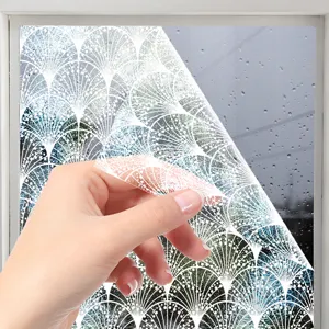 Closeup detail showing white lace pattern static window film being peeled off glass.