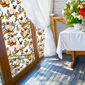Gros plan du film pour fenêtre décoratif avec motif de chat siamois et de fruits.