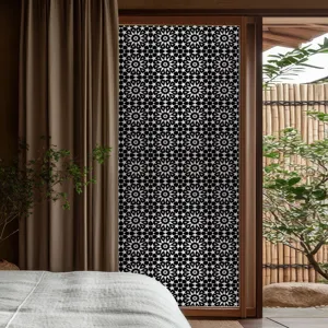 Gros plan détaillé du film pour fenêtre géométrique noir et blanc sur porte en verre intérieure.
