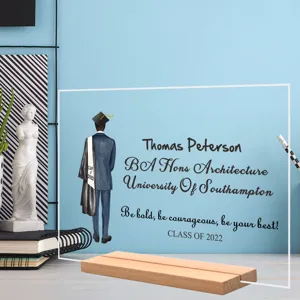 Close-up van acryl afstudeerbureaubord met gepersonaliseerd studentenontwerp en houten voet.