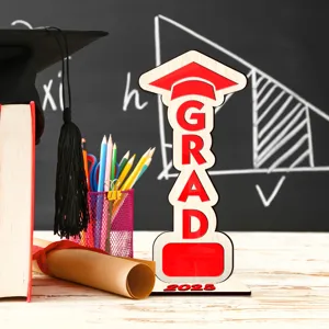 Primer plano del cartel de mesa de graduación de madera GRAD 2025 con accesorios.
