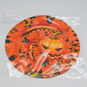 Close-up detail of Halloween party disposable plates featuring orange pumpkin and ghost pattern design.