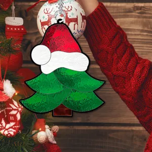 Gros plan sur la décoration suspendue en forme de sapin de Noël avec bonnet de Père Noël.