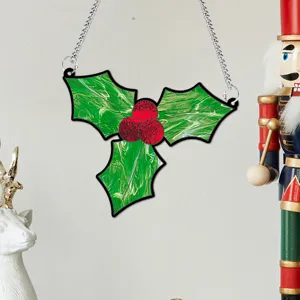 Gros plan sur la décoration suspendue de houx de Noël avec chaîne en métal pour la maison.