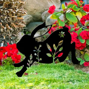 Vue détaillée du piquet de jardin lapin noir avec des motifs floraux creux dans la pelouse.