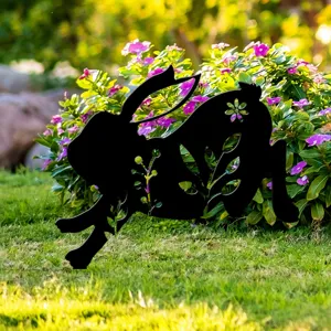 Vue rapprochée détaillée du piquet de jardin lapin noir sur une pelouse verte avec des fleurs.
