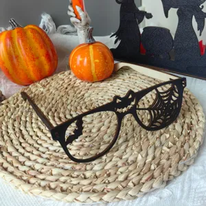 Detailaufnahme der hölzernen Halloween-Brille mit Fledermaus- und Spinnennetz-Motiven.