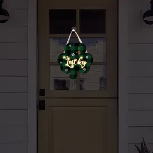 Plaque suspendue trèfle écossais vert Saint-Patrick avec détail de lumière lumineuse.
