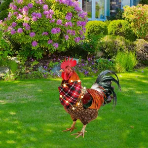 Paletto da giardino in metallo a forma di gallo con sciarpa scozzese e luci natalizie.
