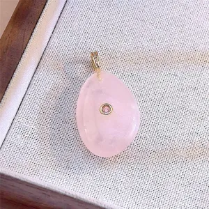 ciondolo a goccia in quarzo rosa vista dettagliata, gancio dorato con pietra brillante.