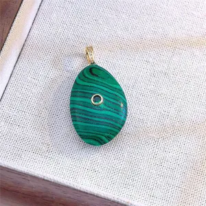 Squisito ciondolo in malachite vista dettagliata con forma di ciottolo unica e pietra centrale.