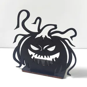 Primo piano dettagliato del decoro di zucca di Halloween in legno intagliato nero con viticci intricati.