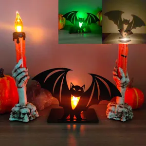 Dettaglio della luce notturna pipistrello in legno e portacandela teschio per Halloween.