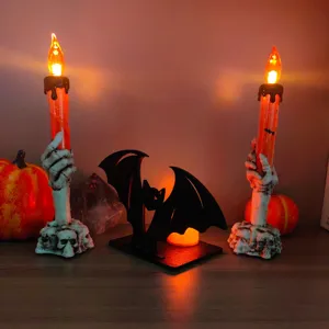 Dettaglio del portacandela pipistrello e mano di scheletro per decorazione da tavola di Halloween.