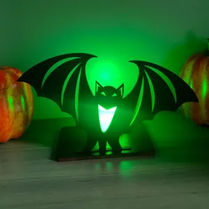 Vista dettagliata della decorazione da tavolo pipistrello in legno luminosa verde.