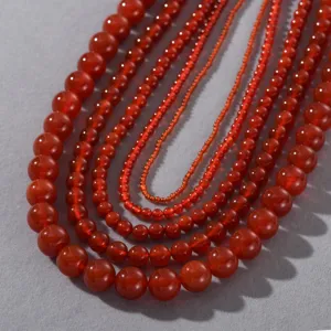 Detailaufnahme der roten Achat Perlenkette mit glänzenden runden Edelsteinperlen im Detail.